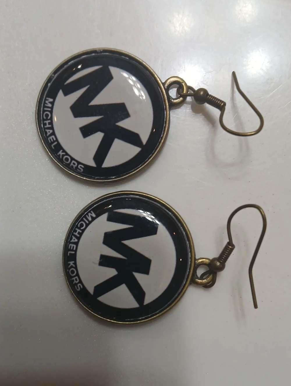 Michael Kors round logo dangle earrings feature the brand's iconic 